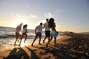 grupo de personas corriendo en la playa foto