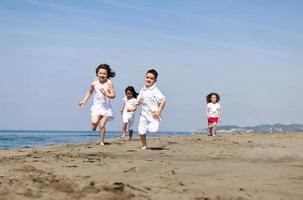 Grupo de niños felices jugando en la playa foto