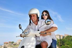 Portrait of happy young love couple on scooter enjoying summer time photo