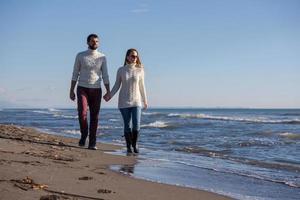 Loving young couple on a beach at autumn sunny day photo