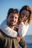 pareja divirtiéndose en la playa durante el otoño foto