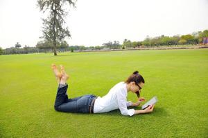 hermosa mujer joven con tableta en el parque foto