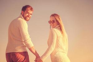 Loving young couple on a beach at autumn sunny day photo