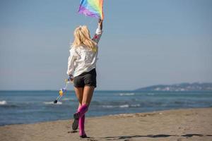 Young Woman with kite at beach on autumn day photo