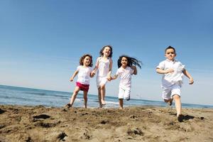 Grupo de niños felices jugando en la playa foto