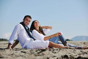 pareja joven disfrutando de un picnic en la playa foto