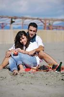 young couple enjoying  picnic on the beach photo