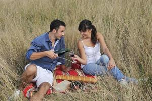 happy couple enjoying countryside picnic in long grass photo