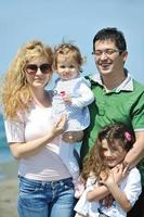 familia joven feliz divertirse en la playa foto