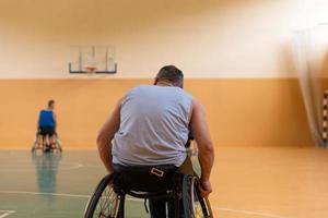 Close up photo of wheelchairs and handicapped war veterans playing basketball on the court