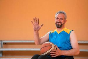 Close up photo of wheelchairs and handicapped war veterans playing basketball on the court