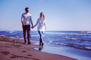 Loving young couple on a beach at autumn sunny day photo