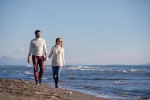 Loving young couple on a beach at autumn sunny day photo