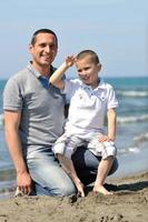 feliz padre e hijo se divierten y disfrutan del tiempo en la playa foto