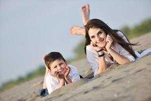 mamá e hijo relajándose en la playa foto