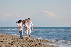 familia joven feliz divertirse en la playa foto