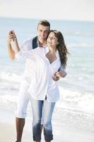 happy young couple have fun at beautiful beach photo