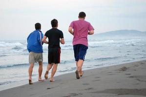 three friends jogging at beach photo