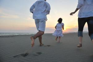 happy young family have fun on beach at sunset photo