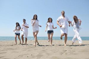 grupo de gente feliz divertirse y correr en la playa foto