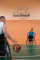 veteranos de guerra discapacitados en acción mientras juegan baloncesto en una cancha de baloncesto con equipo deportivo profesional para discapacitados foto