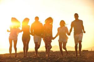 grupo de jóvenes felices divertirse en la playa foto