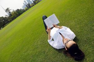 Young woman reading a book in the park photo