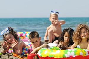 grupo infantil divertirse y jugar con juguetes de playa foto