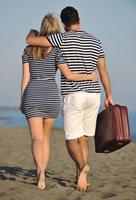 couple on beach with travel bag photo