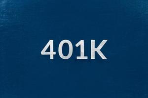 the word 401k laid with silver brushed metal letters on classic blue surface - centered in flat lay directly above perspective photo