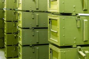 stacks of abstract green military crates without any markings - close-up with selective focus and background blur photo