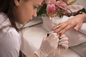 manos de mujer recibiendo una manicura foto