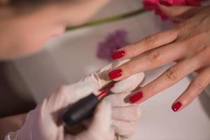 manos de mujer recibiendo una manicura foto