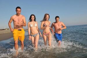 grupo de gente feliz divertirse y correr en la playa foto