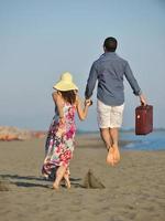 couple on beach with travel bag photo