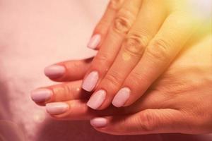 dedos de mujer con manicura francesa foto