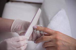 manos de mujer recibiendo una manicura foto