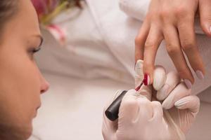 manos de mujer recibiendo una manicura foto