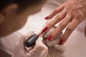 manos de mujer recibiendo una manicura foto