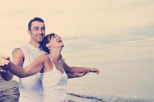 feliz pareja joven divertirse en la hermosa playa foto