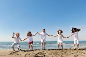 Grupo de niños felices jugando en la playa foto