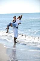 feliz pareja joven divertirse en la hermosa playa foto