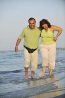 happy seniors couple  on beach photo