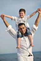 happy father and son have fun and enjoy time on beach photo