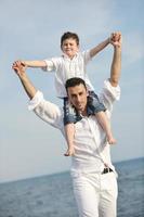 feliz padre e hijo se divierten y disfrutan del tiempo en la playa foto