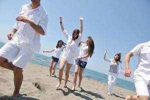 grupo de gente feliz divertirse y correr en la playa foto