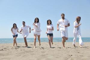 grupo de gente feliz divertirse y correr en la playa foto