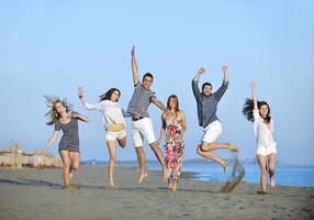 grupo de jóvenes felices divertirse en la playa foto