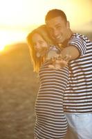 happy young couple have romantic time on beach photo