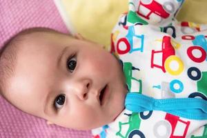 top view of newborn baby boy lying on colorful blankets photo